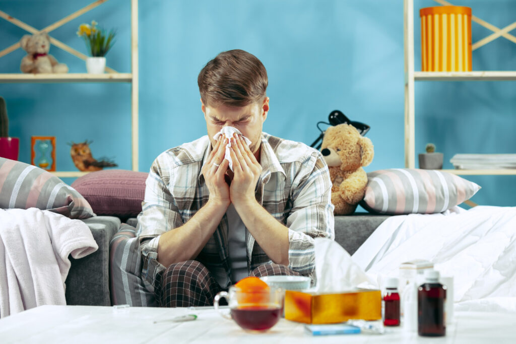 Bearded Sick Man With Flue Sitting Sofa Home Blowing His Nose Winter Illness Influenza Pain Concept Relaxation Home Healthcare Concepts